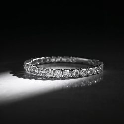 Bir tane elmas bileklik siyah beyaz ve loş bir ortamda bakılırken bilekliğin üstüne beyaz bi ışık yansicak estetik fotoğraf